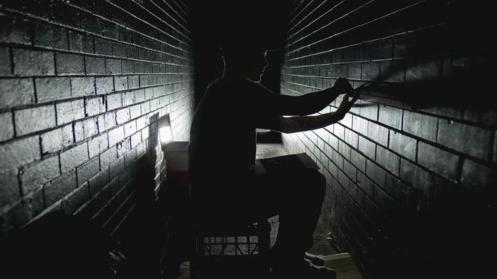 man in a dark tunnel-like room