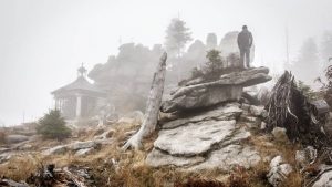 A man in a rocky foggy landscape - imagery for "Fetching Fossils" by Heath Brougher
