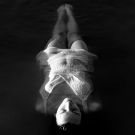 a woman floating in water - imagery for "Swimming with Angels" by Anna Geary-Meyer