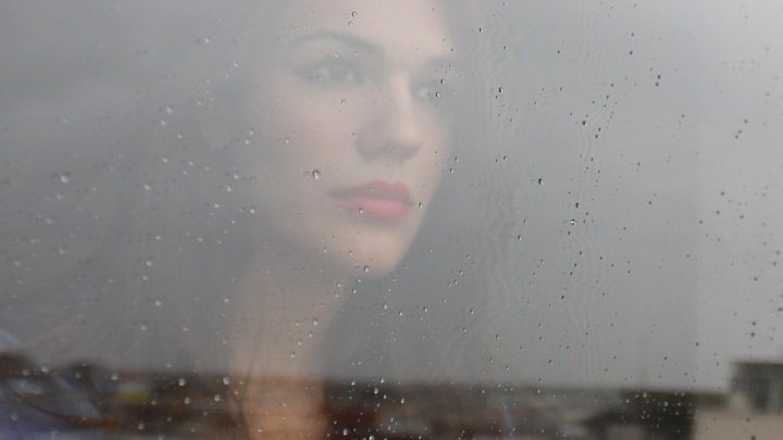 woman looking out the window in the rain