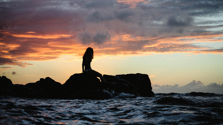 Silhouette on shore at sunset - imagery for "Fabric" by Carol Ellis