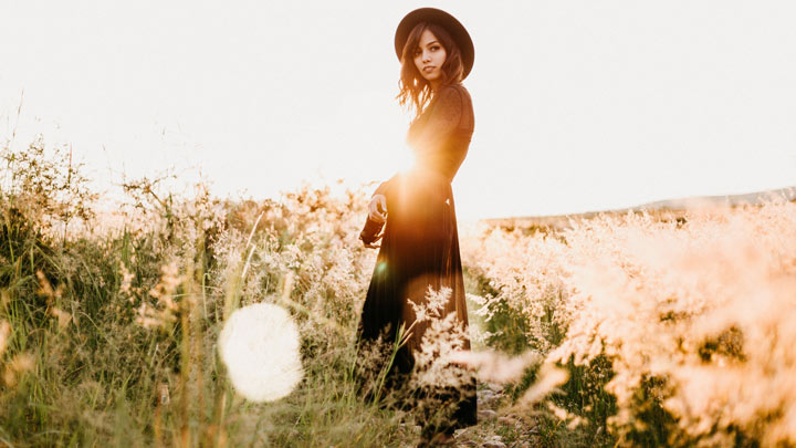 A woman standing in a field, dressed in black - image for Black Dress by Kenneth Pobo