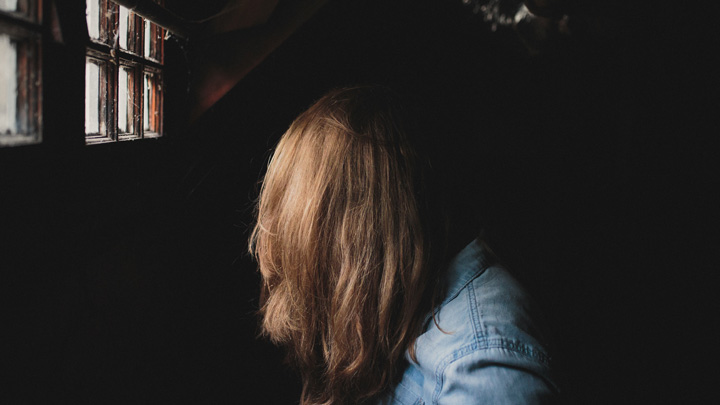 A woman in a dark room, image for One More Bad Day by Tracy Mishkin